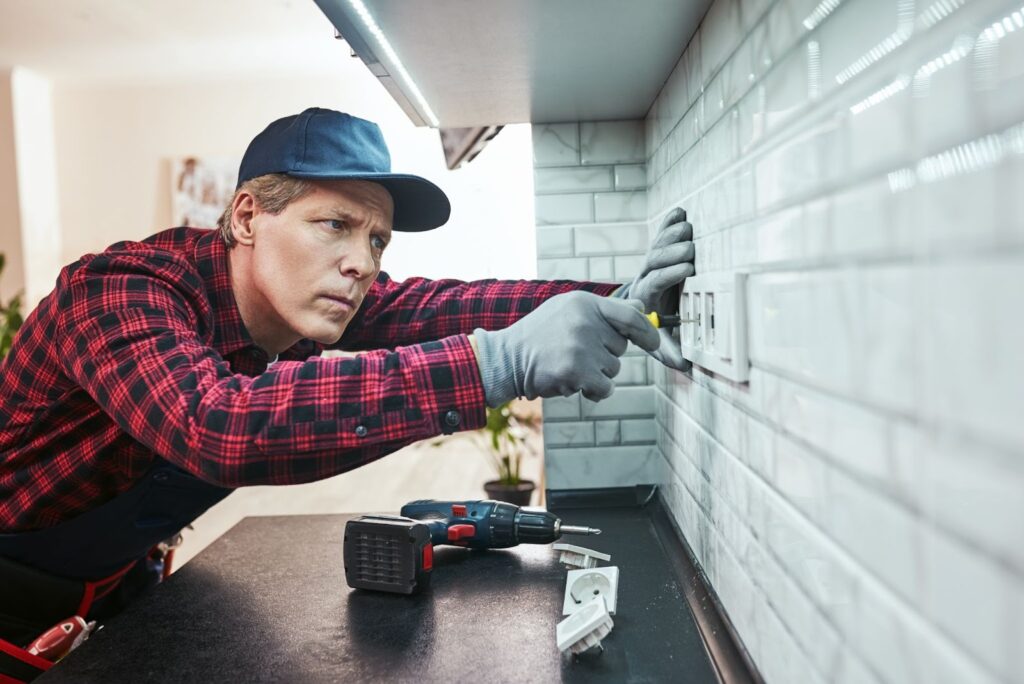 Electrician setting new wall sockets during a residential electrical upgrade.