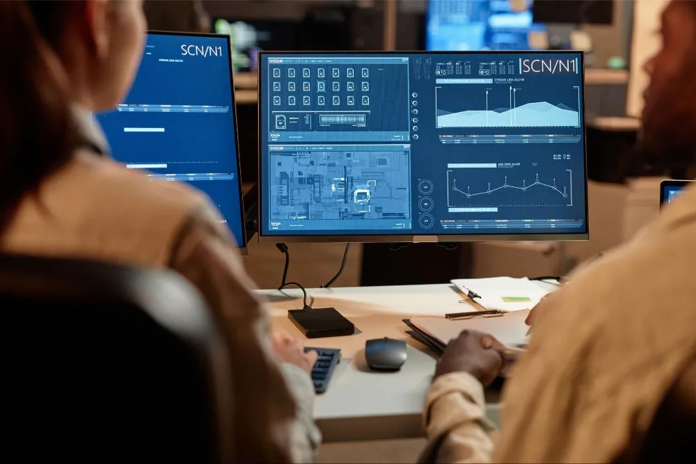 Engineers reviewing SCADA dashboard charts for system performance insights.