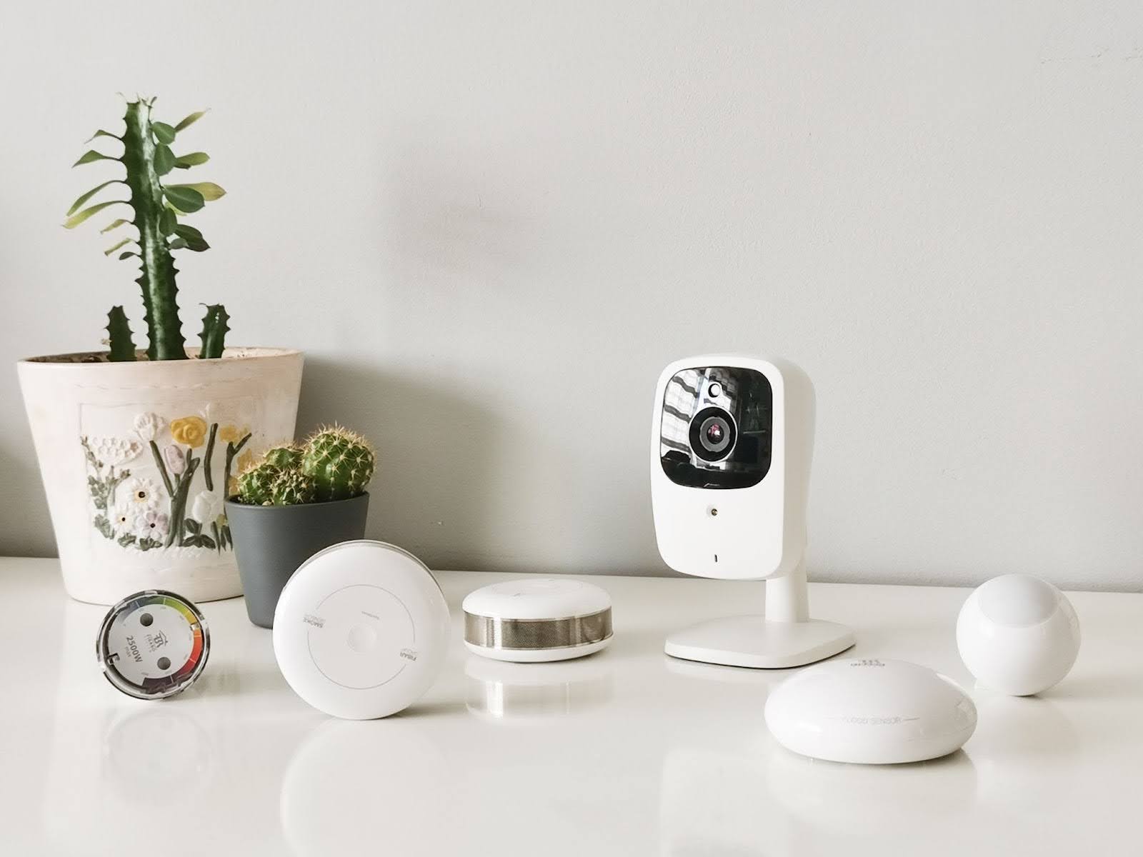 Multiple smart home devices arranged on a surface, including a camera and connected accessories.